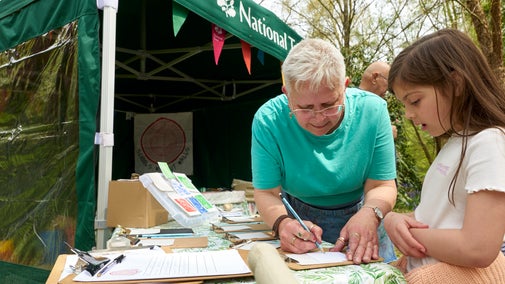 A child trying out some nature crafts at an outdoor workshop event
